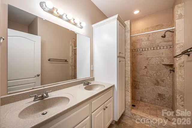 a bathroom with a shower sink and mirror