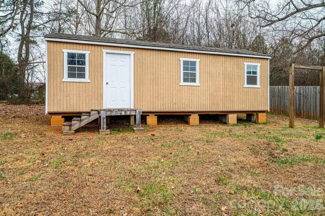a view of a house with backyard and trees