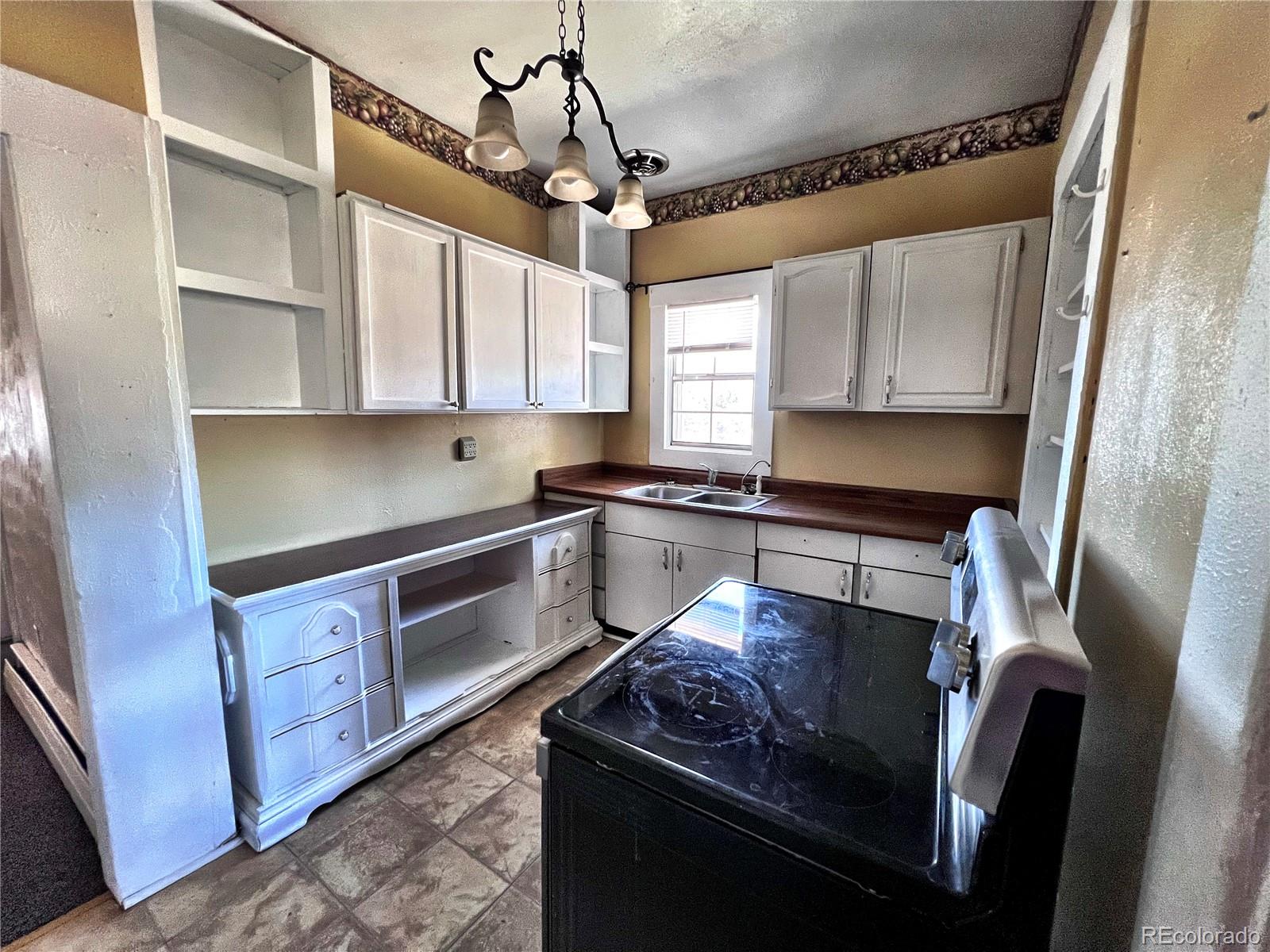 125 Seventh Street Hugo, CO 80821 - Photo 8 of 24 a kitchen with stainless steel appliances granite countertop a sink a stove and a refrigerator