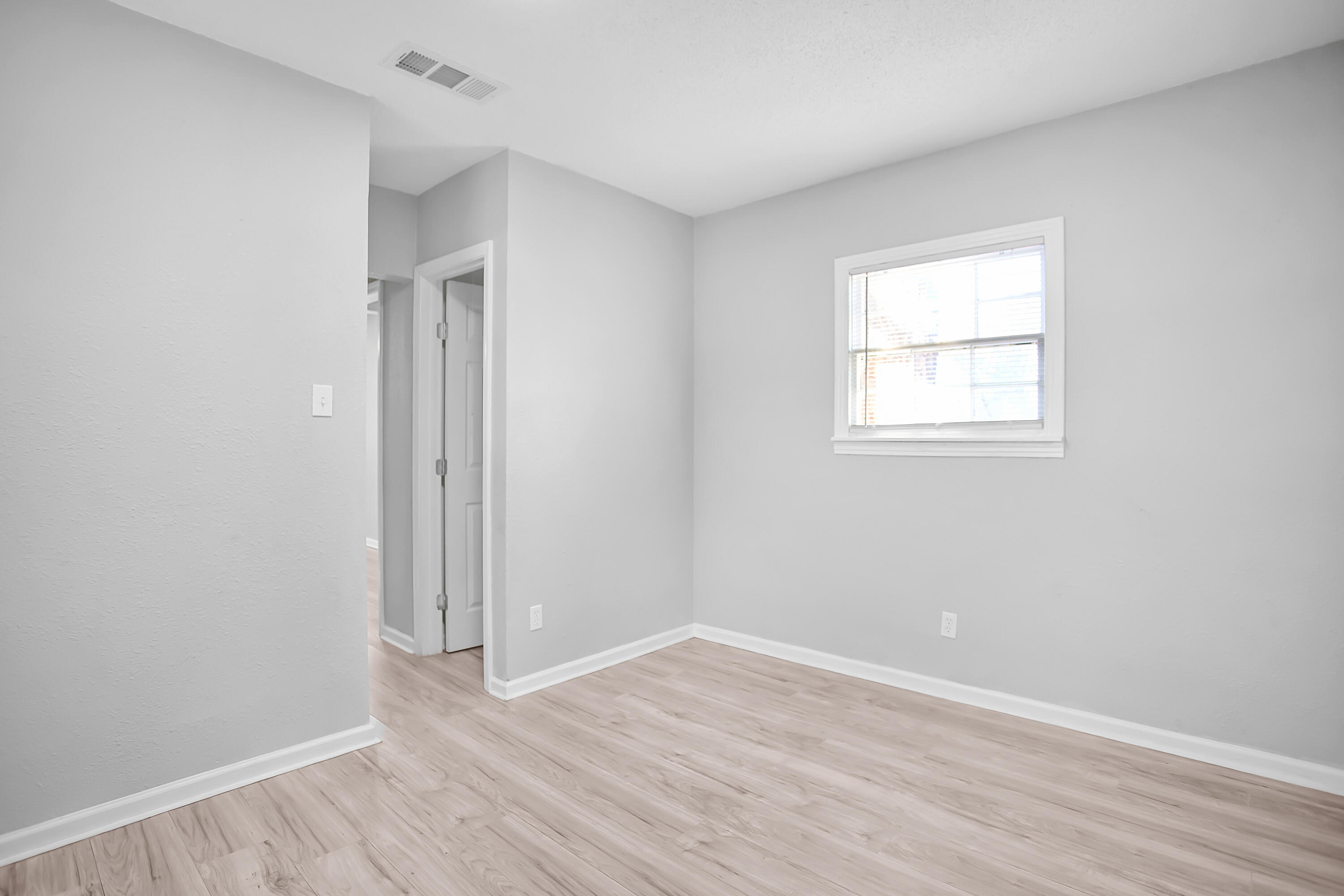 2430 31st Street Lubbock, TX 79411 - Photo 18 of 46 an empty room with wooden floor and windows