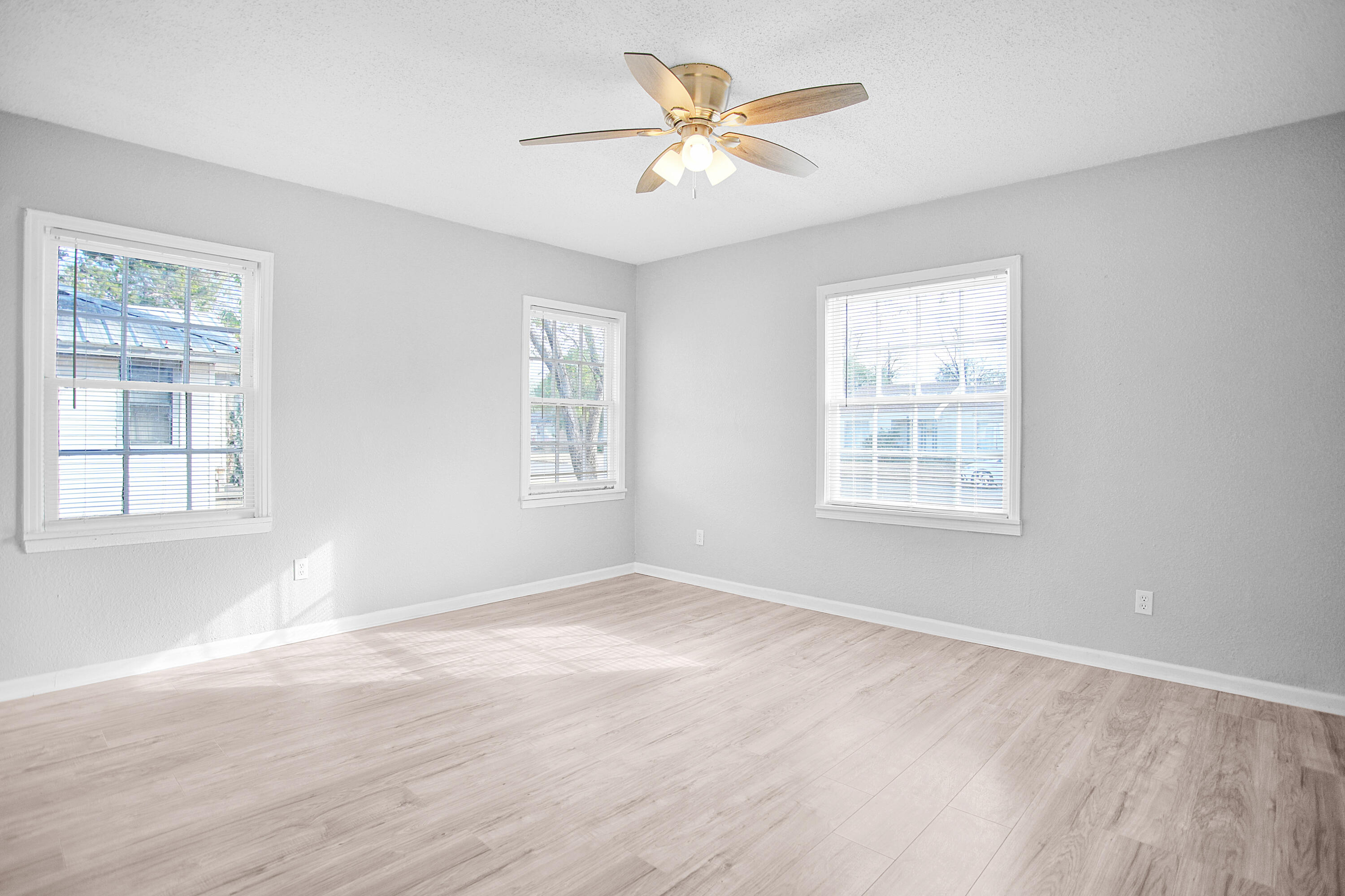 2430 31st Street Lubbock, TX 79411 - Photo 2 of 46 a view of a big room with windows and chandelier fan
