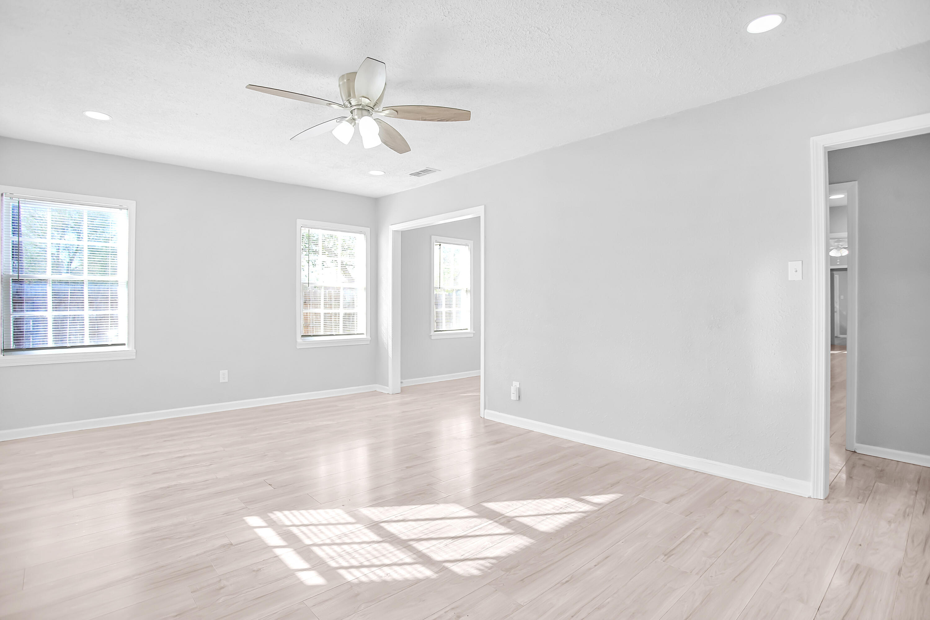 2430 31st Street Lubbock, TX 79411 - Photo 3 of 46 an empty room with wooden floor fan and windows