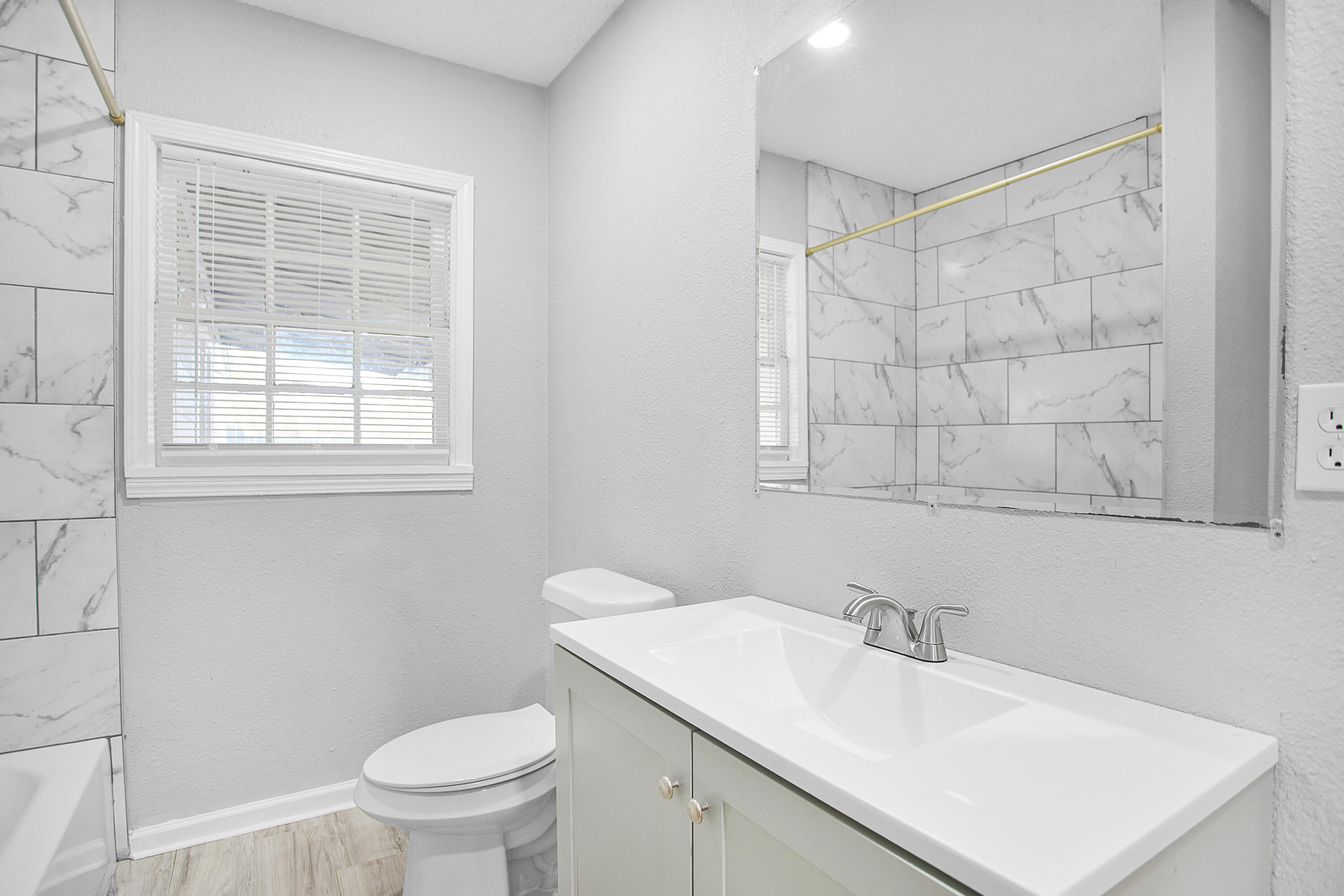 2430 31st Street Lubbock, TX 79411 - Photo 33 of 46 a bathroom with a sink toilet vanity and window