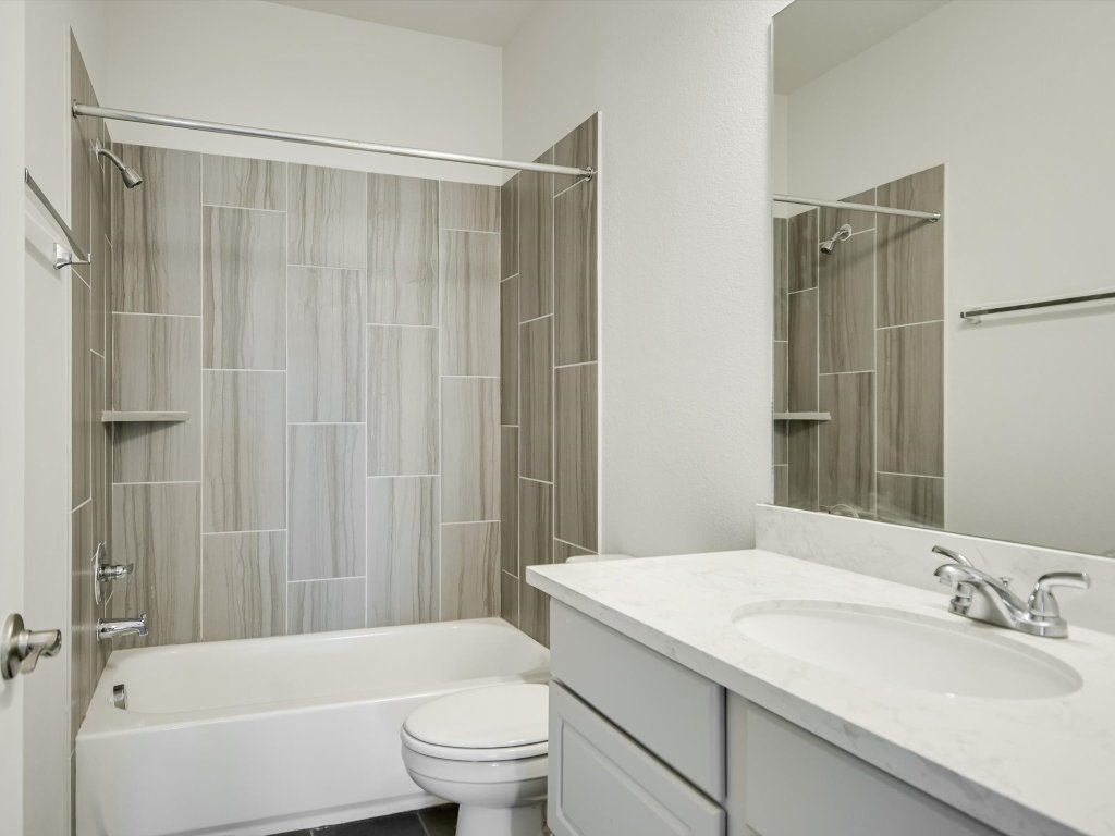 396 Cold Riv Run Kyle, TX 78640 - Photo 16 of 20 a bathroom with a granite countertop sink a toilet and shower