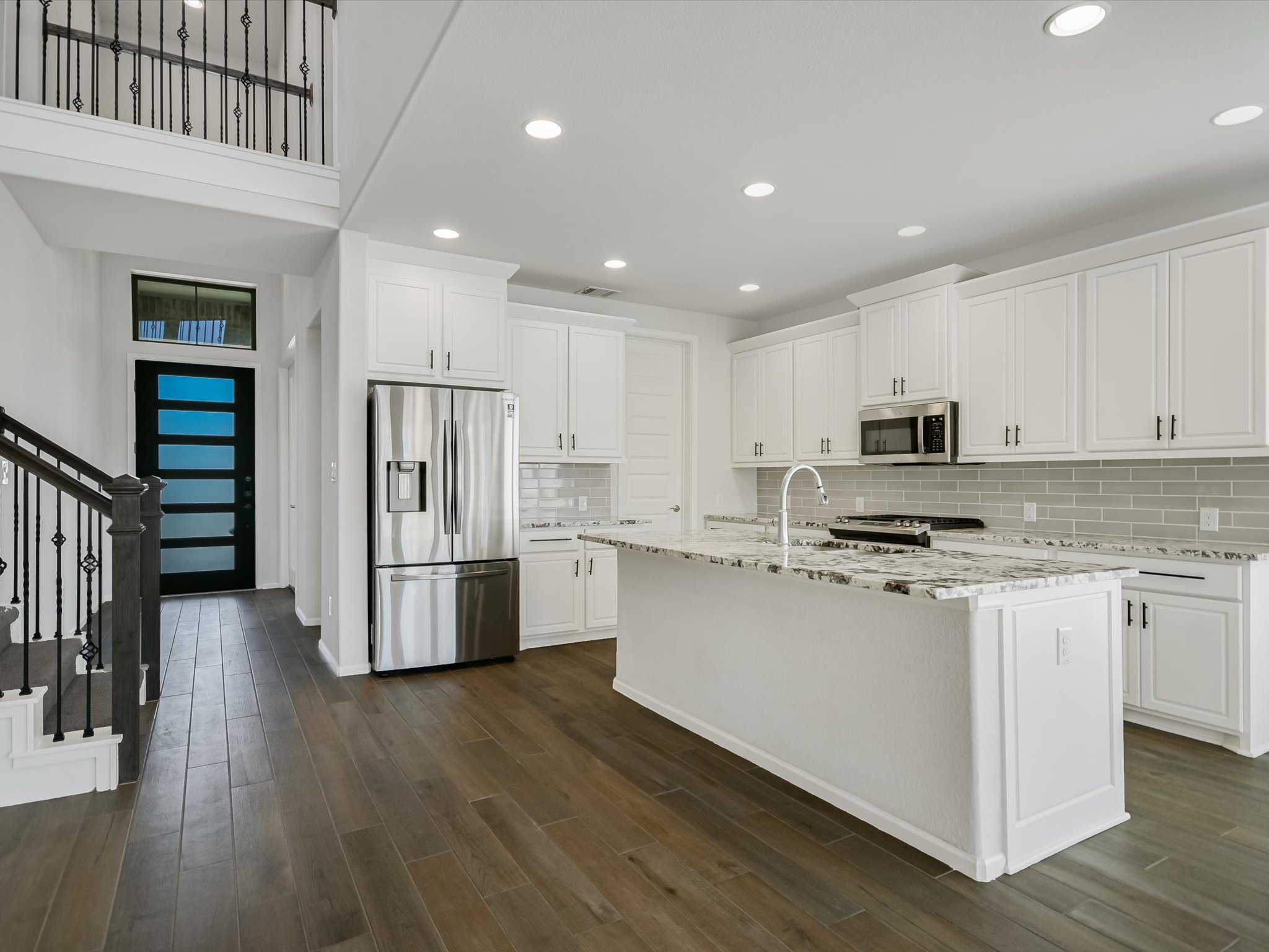 396 Cold Riv Run Kyle, TX 78640 - Photo 5 of 20 a kitchen with stainless steel appliances granite countertop a refrigerator a stove and a wooden floors