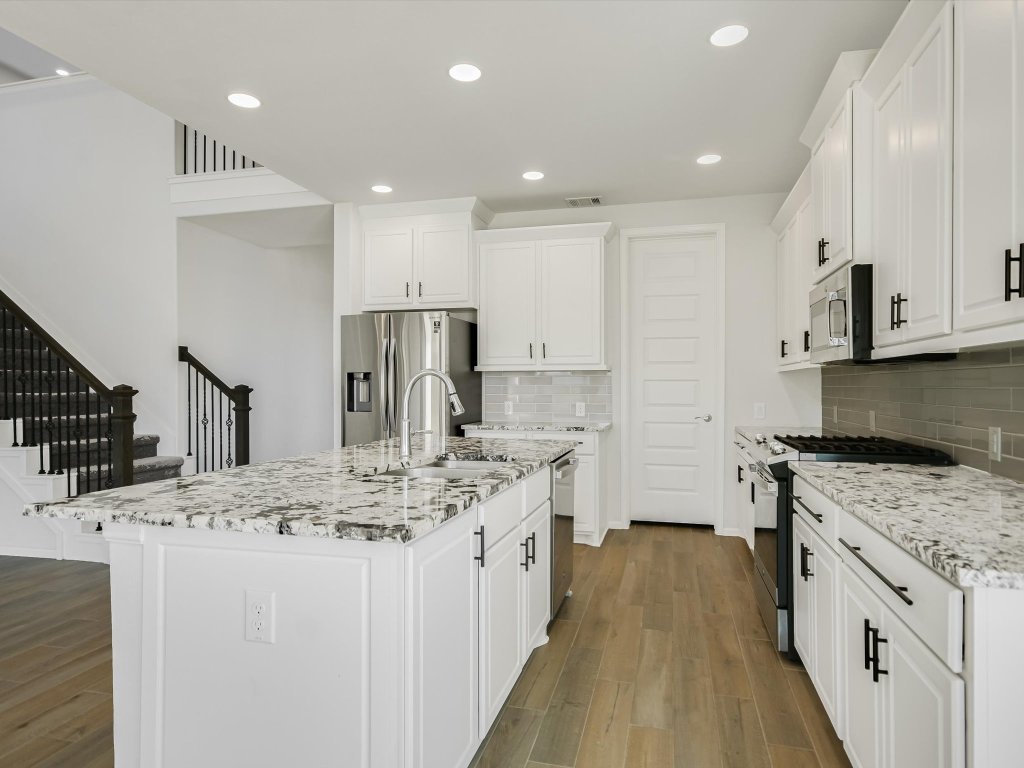 396 Cold Riv Run Kyle, TX 78640 - Photo 6 of 20 a kitchen with stainless steel appliances granite countertop a sink stove and refrigerator