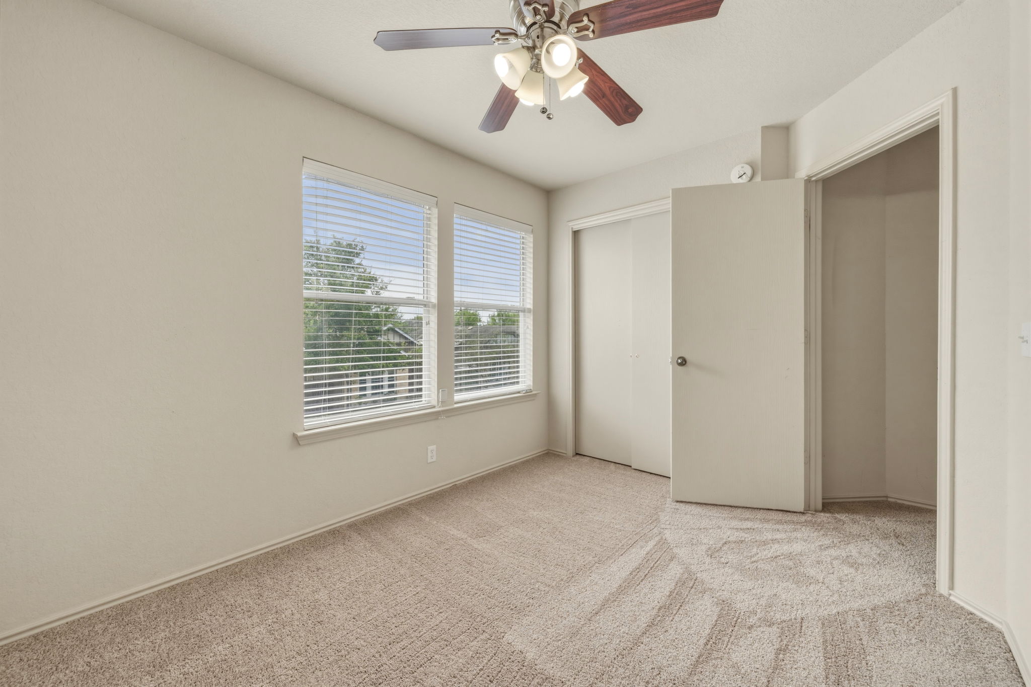 4528 Best Way Austin, TX 78725 - Photo 20 of 40 Unfurnished bedroom featuring light colored carpet, a ceiling fan, and a closet