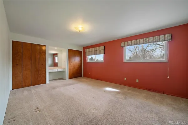 an empty room with windows and closet