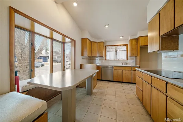 a kitchen with stainless steel appliances granite countertop a sink counter space cabinets and a large window