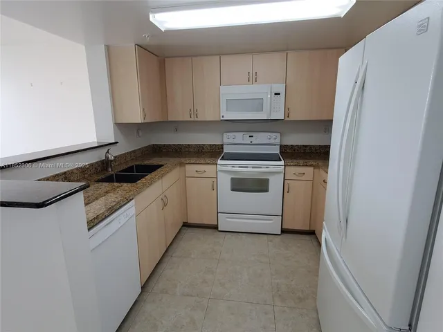 a kitchen with a stove sink and refrigerator