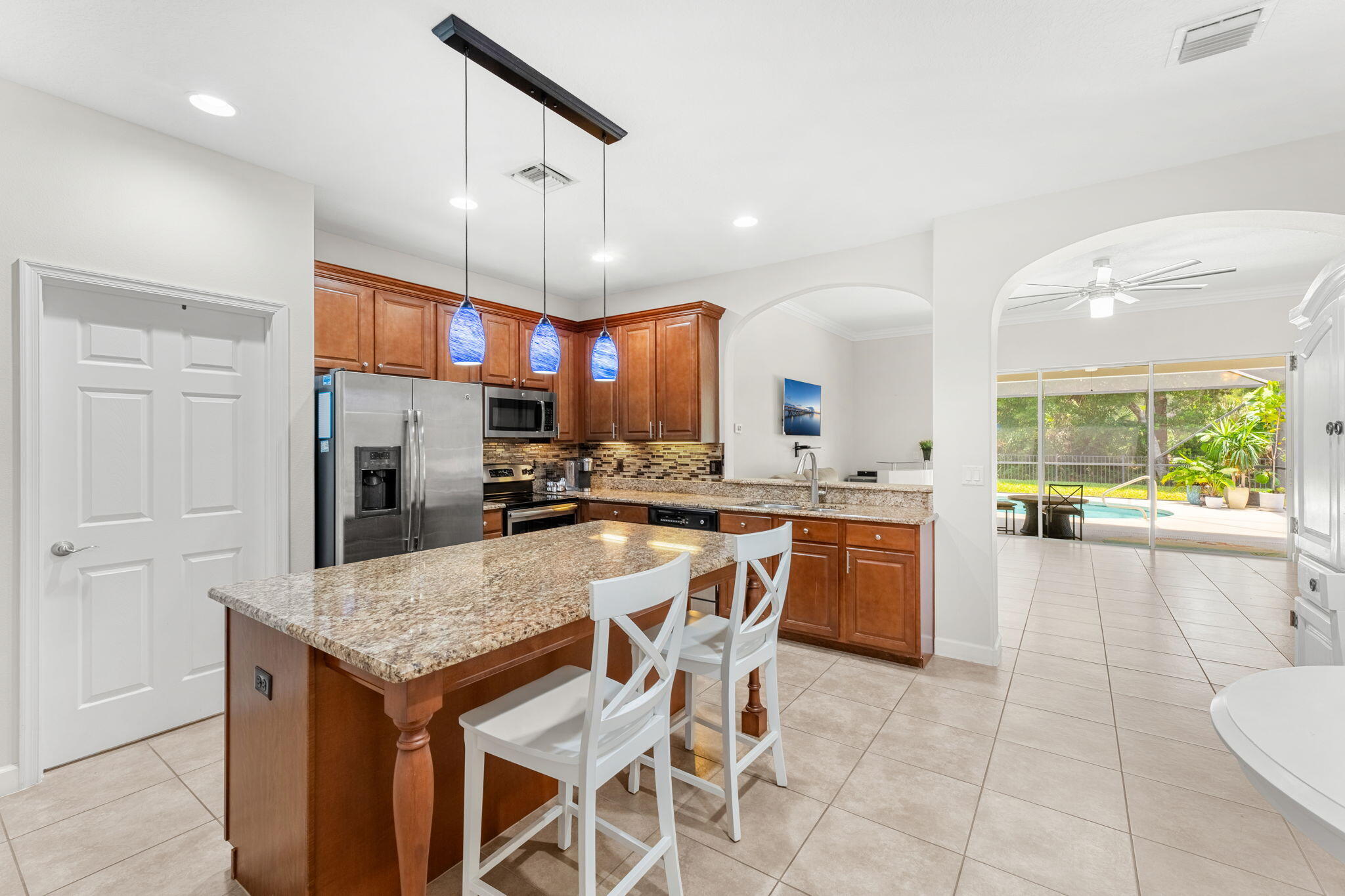 7657 Fieldstone Ranch Square Vero Beach, FL 32967 - Photo 18 of 52 a kitchen with a table chairs refrigerator and microwave