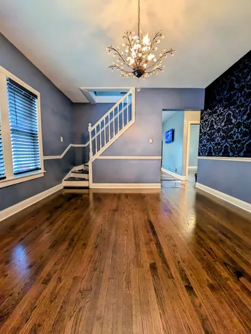 a view of a livingroom with wooden floor and a ceiling fan
