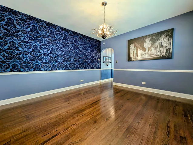 a view of a room with wooden floor and chandelier