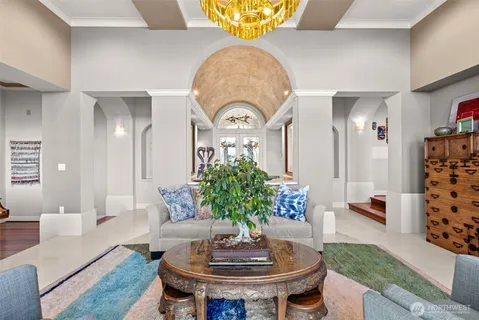 a living room with furniture a fireplace and a chandelier
