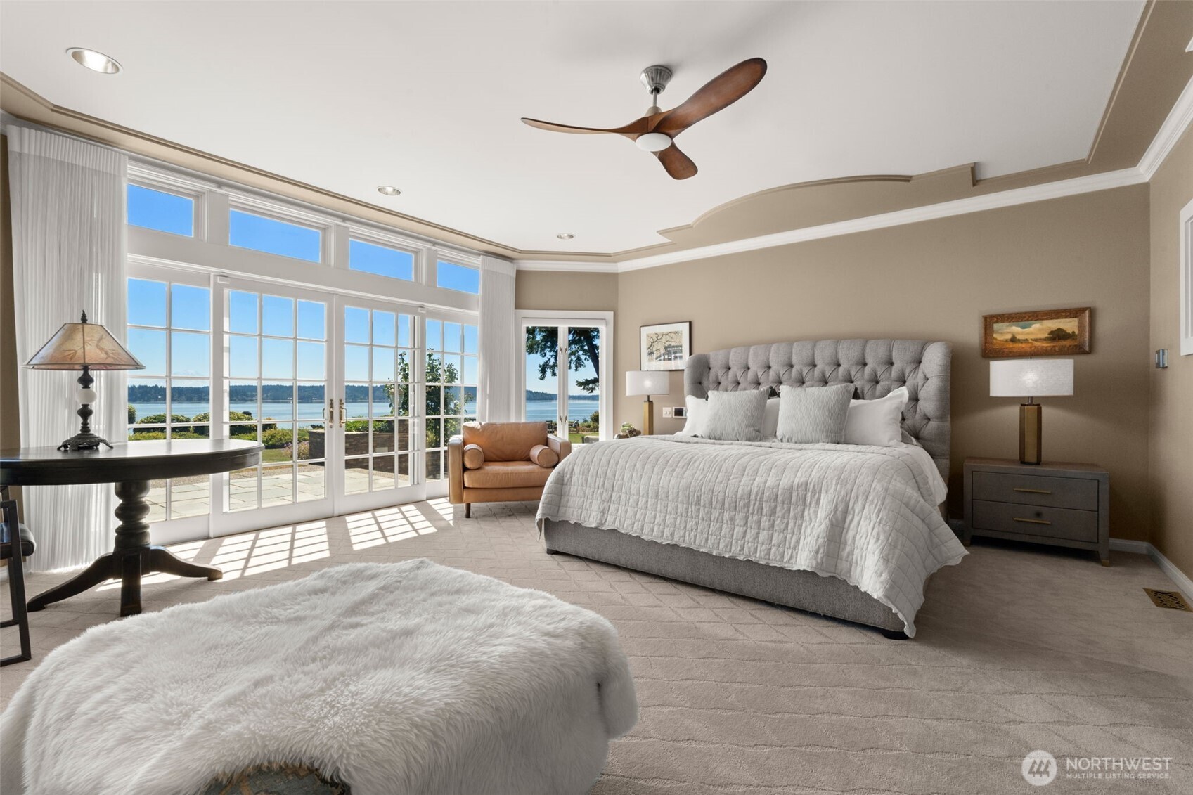 13020 Thomas Road Northwest Gig Harbor, WA 98329 - Photo 20 of 37 a bedroom with a large bed and a chandelier