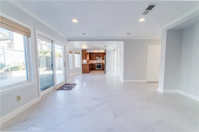 a view of an empty room with window and cabinet