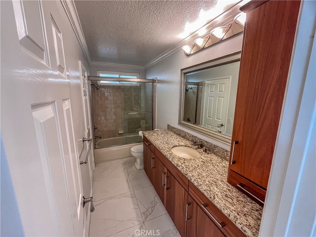 23971 Frigate Drive Laguna Niguel, CA 92677 - Photo 34 of 48 a bathroom with a granite countertop sink a mirror and a shower