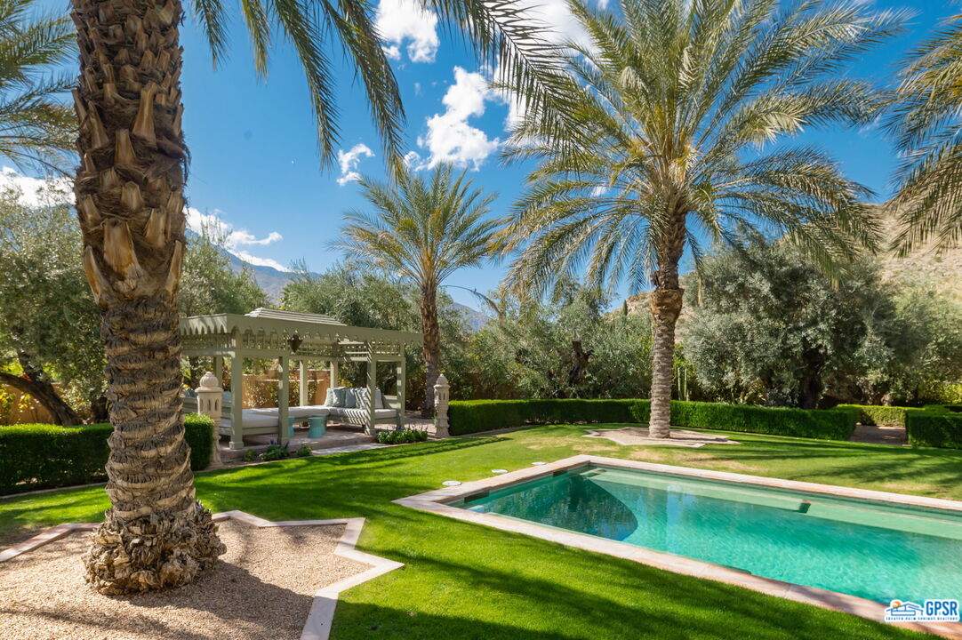 1650 Ave Sevilla Palm Springs, CA 92264 - Photo 11 of 74 a view of a swimming pool with a garden and trees