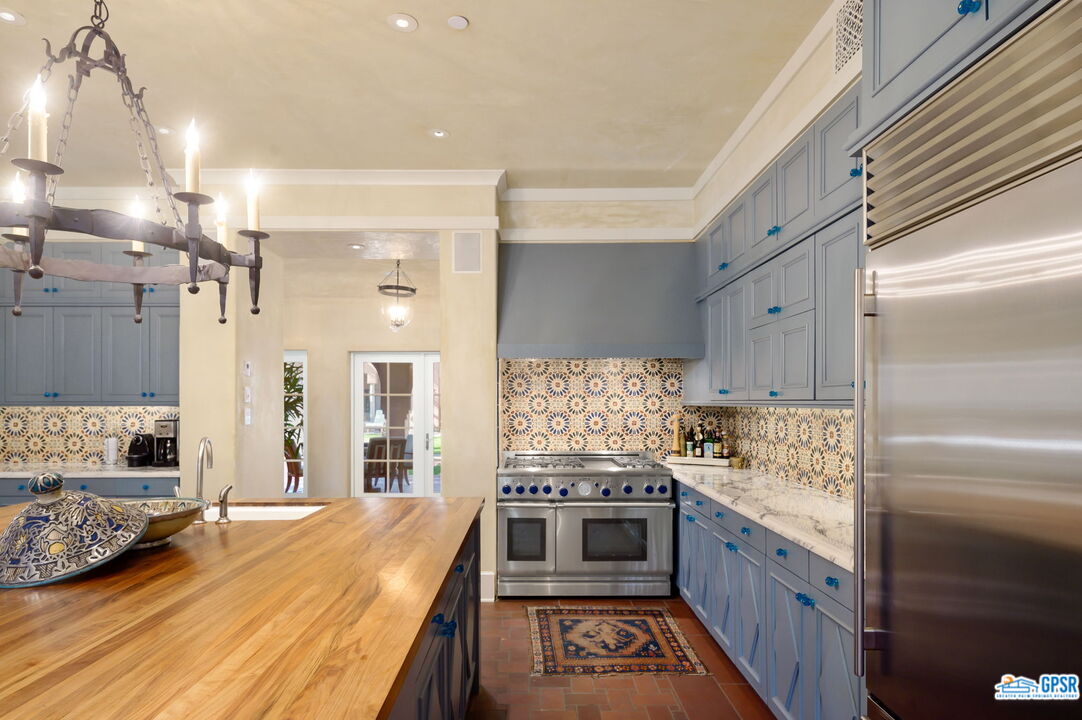 1650 Ave Sevilla Palm Springs, CA 92264 - Photo 34 of 74 a kitchen with stainless steel appliances kitchen island granite countertop a stove and a refrigerator