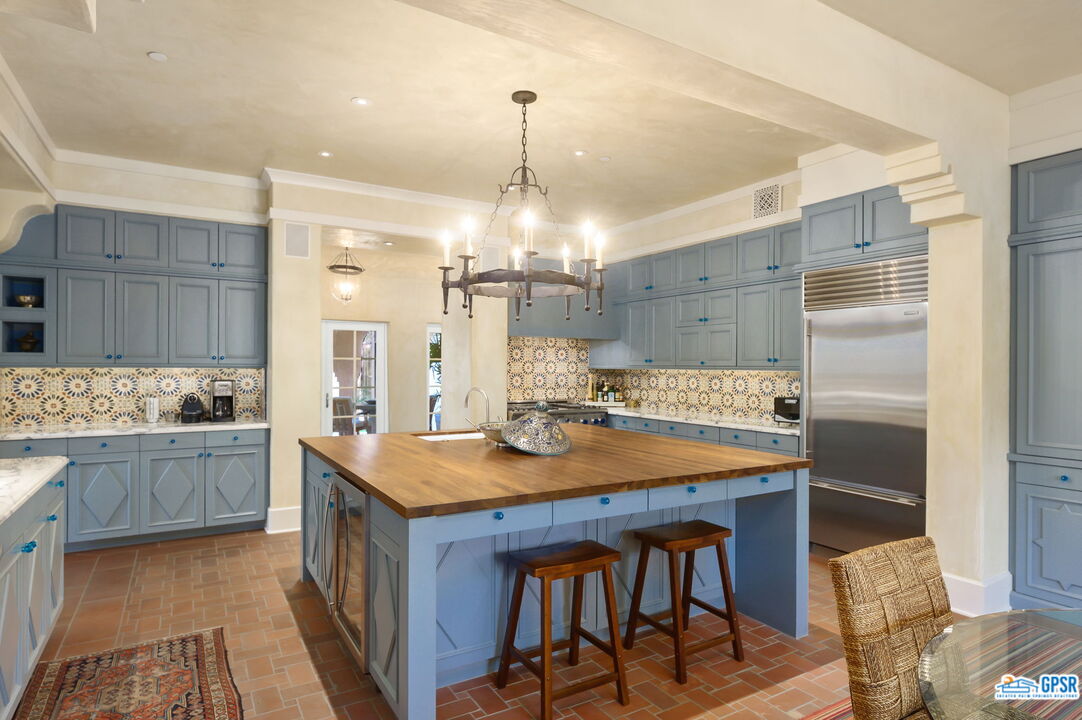 1650 Ave Sevilla Palm Springs, CA 92264 - Photo 35 of 74 a kitchen with stainless steel appliances granite countertop a kitchen island a stove a table and chairs in it