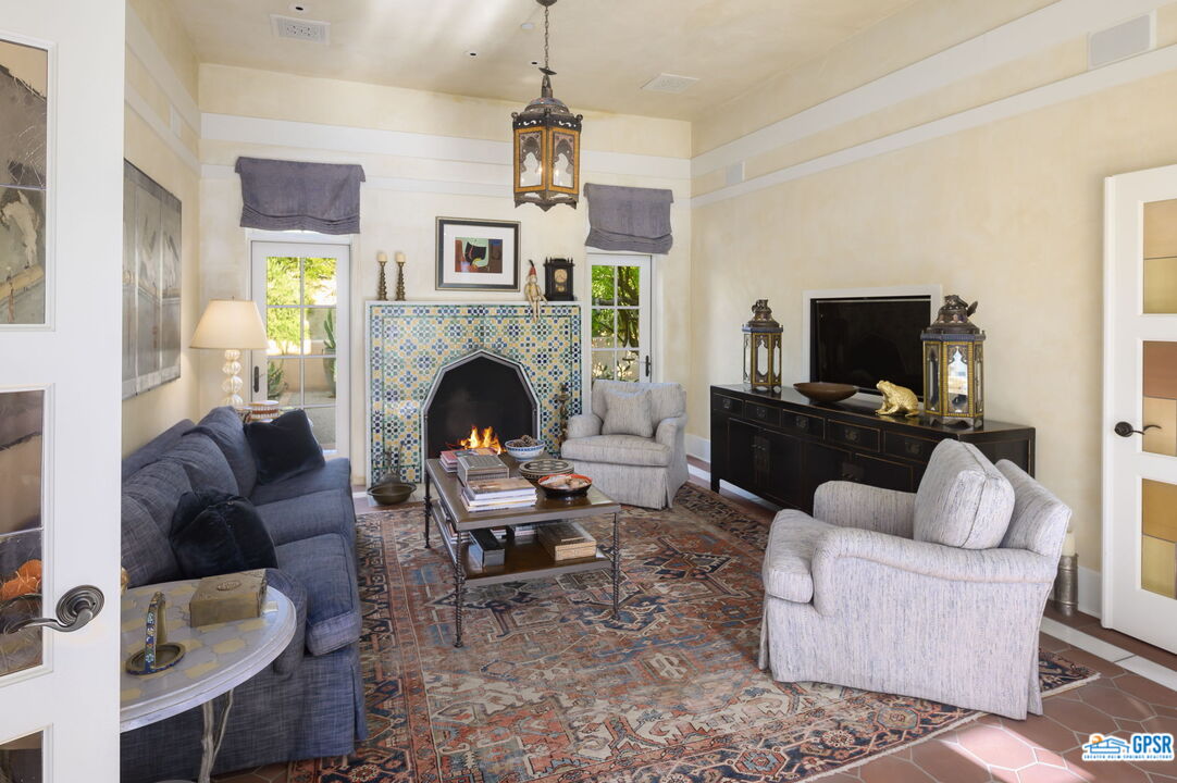 1650 Ave Sevilla Palm Springs, CA 92264 - Photo 43 of 74 a living room with furniture a fireplace and a flat screen tv