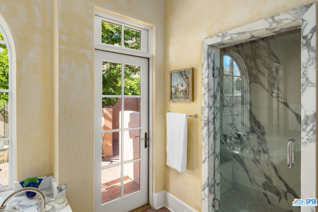 1650 Ave Sevilla Palm Springs, CA 92264 - Photo 48 of 74 a bathroom with a glass shower door and a window