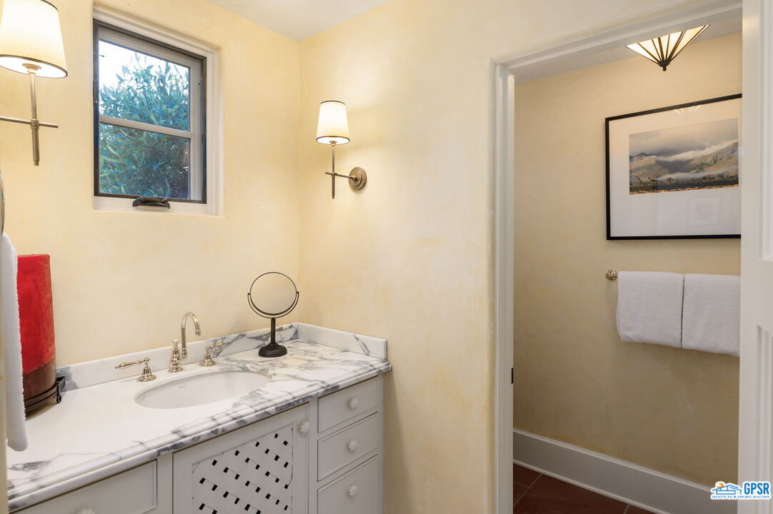 1650 Ave Sevilla Palm Springs, CA 92264 - Photo 52 of 74 a bathroom with a granite countertop sink and a mirror
