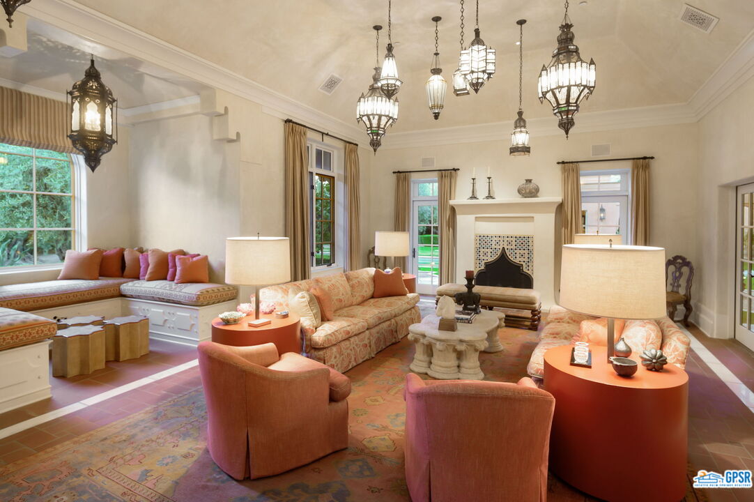 1650 Ave Sevilla Palm Springs, CA 92264 - Photo 62 of 74 a living room with furniture a fireplace and a chandelier
