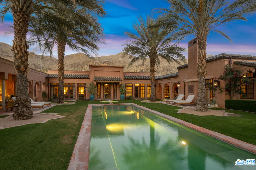 1650 Ave Sevilla Palm Springs, CA 92264 - Photo 66 of 74 a view of a swimming pool with a table and chairs under an umbrella