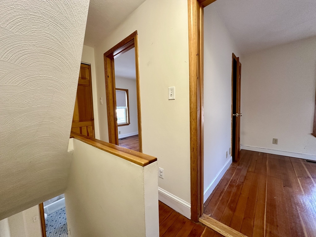 5 Rifle Court, Unit 5 Watertown, MA 02472 - Photo 9 of 14 a view of a hallway with wooden floor and staircase