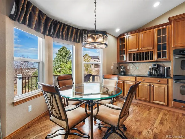 a large kitchen with stainless steel appliances a large counter top a stove and a wooden floors