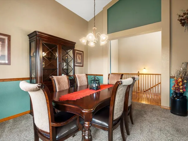 a view of a dining room with furniture and a chandelier