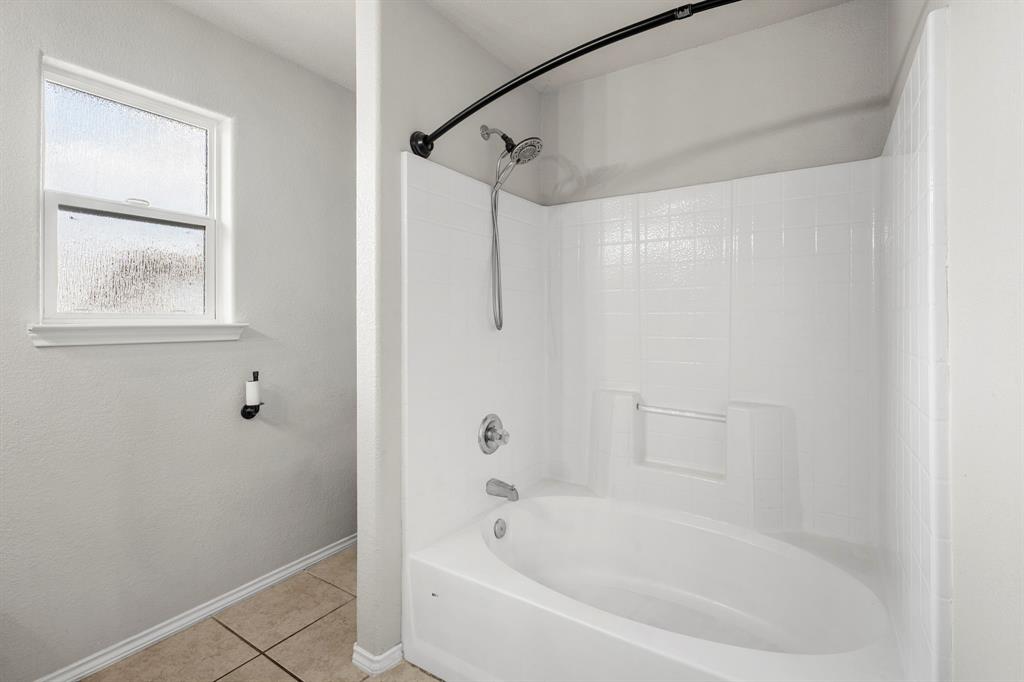 10620 Granada Drive Waco, TX 76708 - Photo 23 of 38 White acrylic tub and shower combination with a curved shower rod