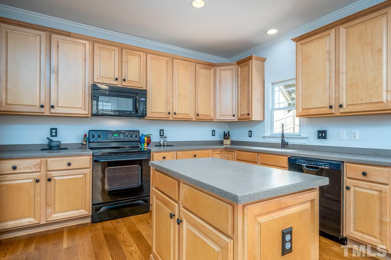 535 Pace Street Raleigh, NC 27604 - Photo 7 of 25 a kitchen with granite countertop a stove sink and cabinets
