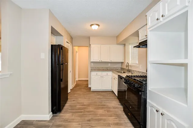 a kitchen with a refrigerator and a stove top oven
