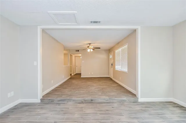 a view of an empty room with wooden floor