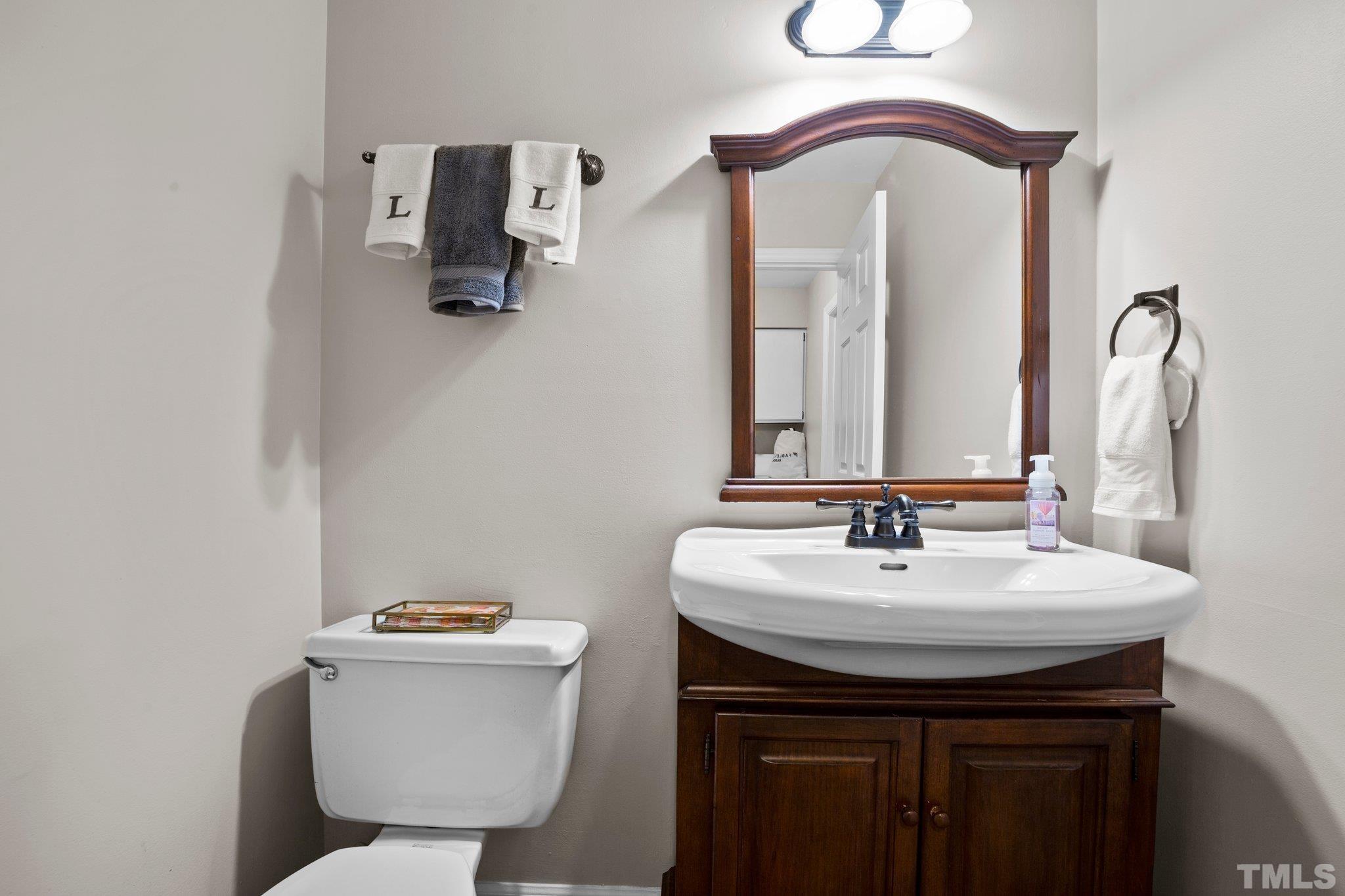 8709 Langtree Lane Raleigh, NC 27613 - Photo 17 of 49 a bathroom with a toilet sink and mirror
