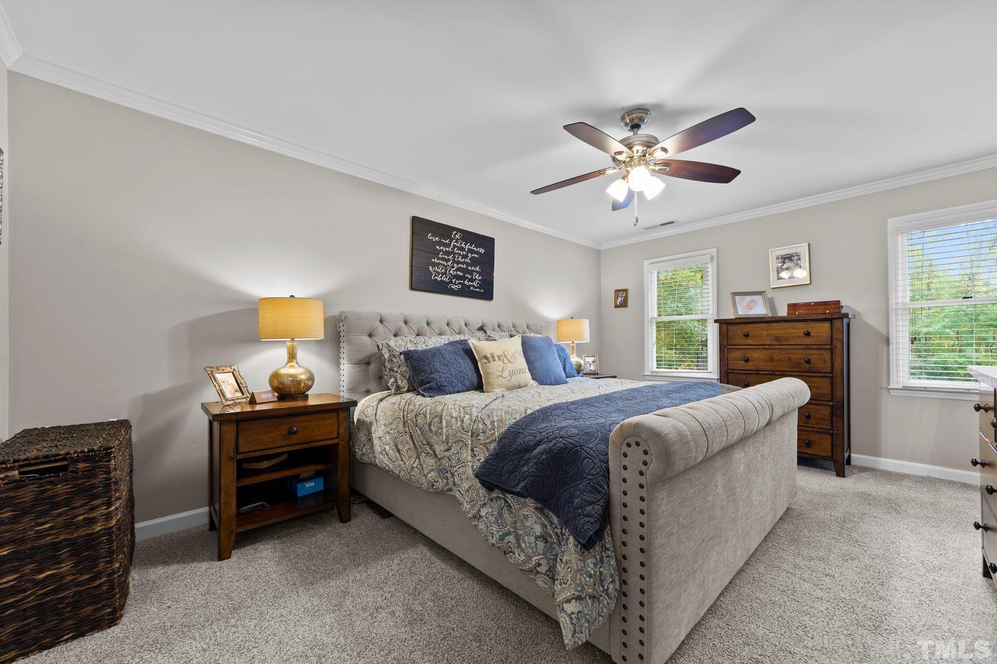 8709 Langtree Lane Raleigh, NC 27613 - Photo 20 of 49 a spacious bedroom with a bed and a chandelier