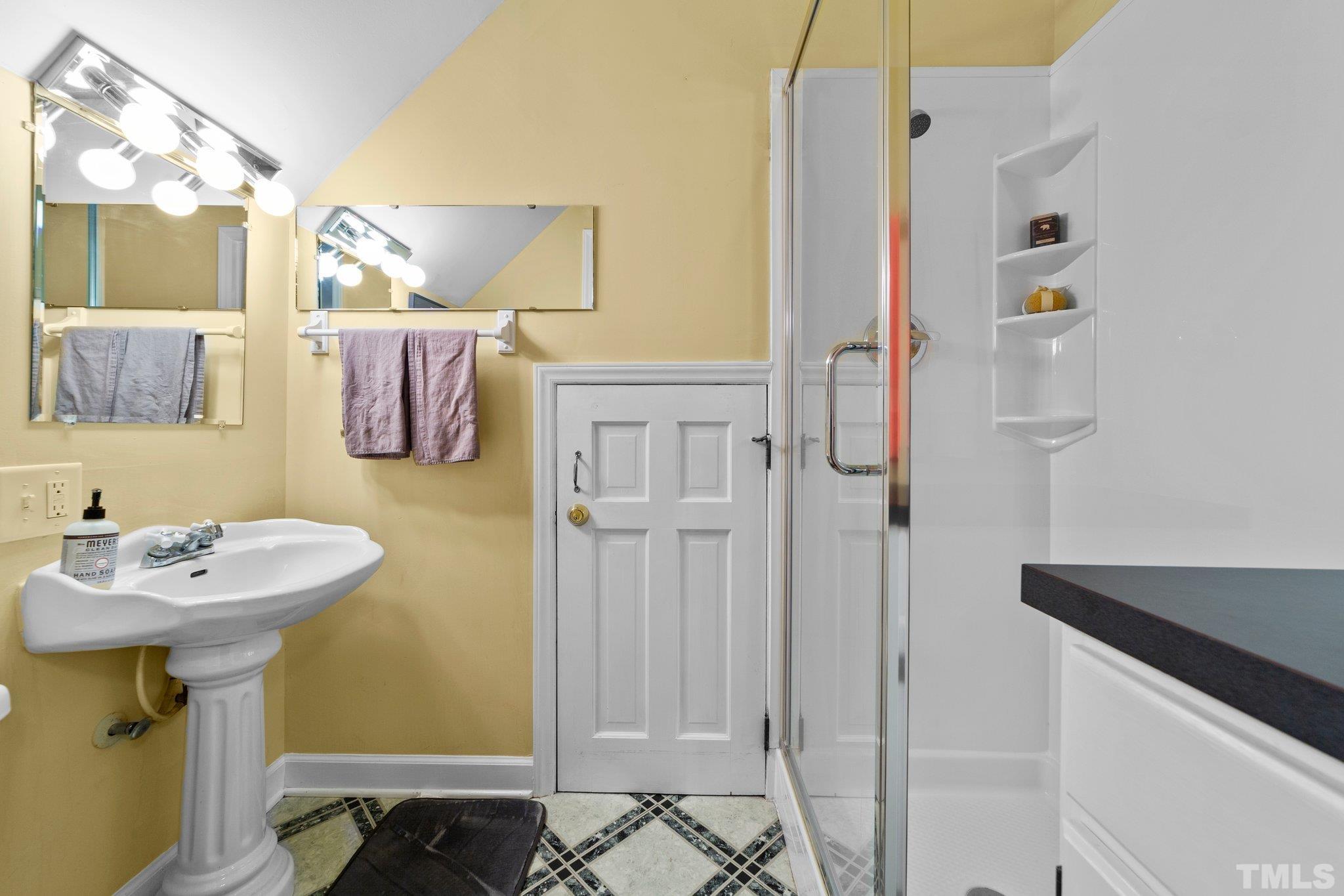 8709 Langtree Lane Raleigh, NC 27613 - Photo 32 of 49 a bathroom with a sink a mirror and a shower