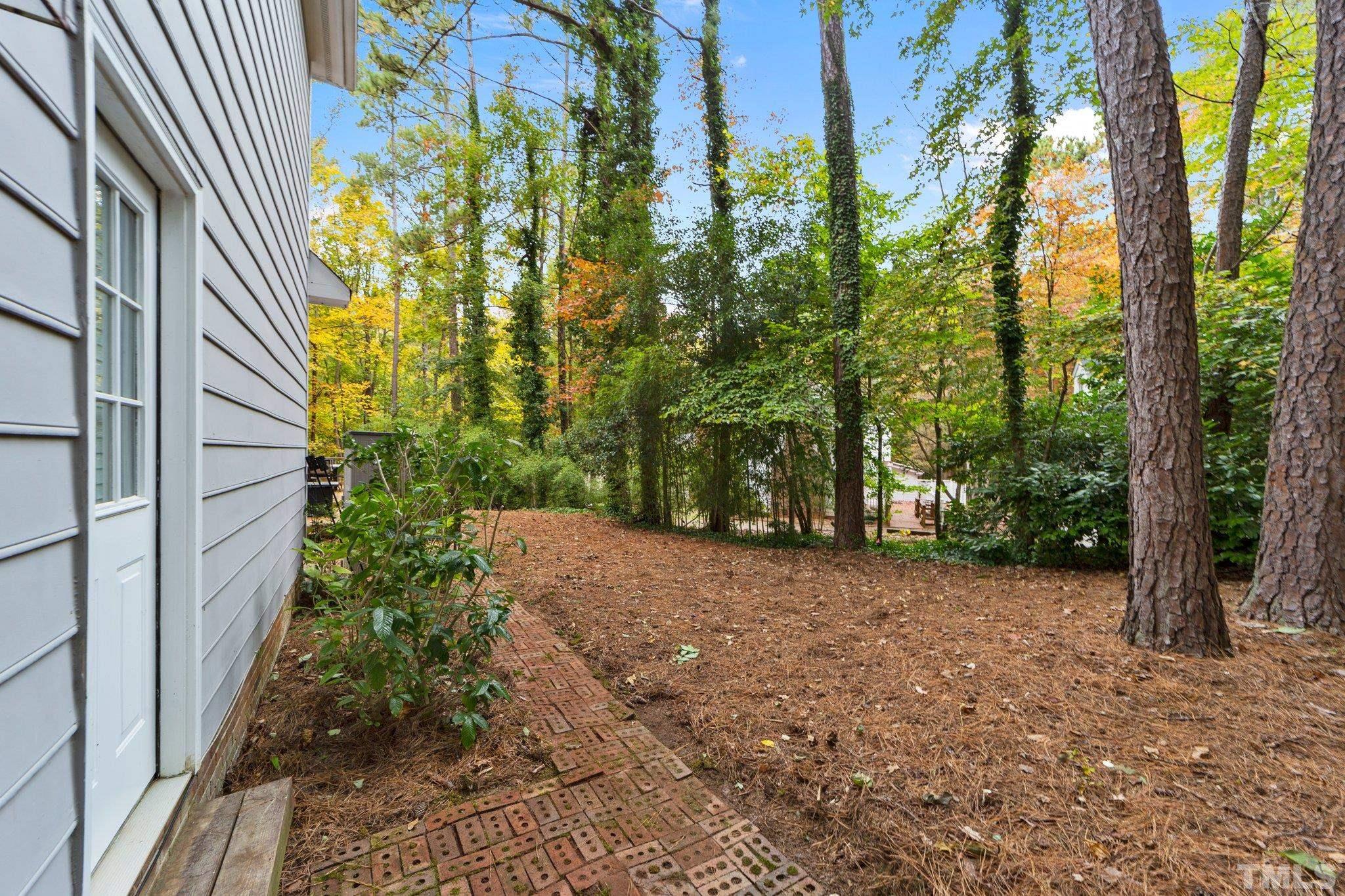 8709 Langtree Lane Raleigh, NC 27613 - Photo 39 of 49 a view of a trees with brick wall