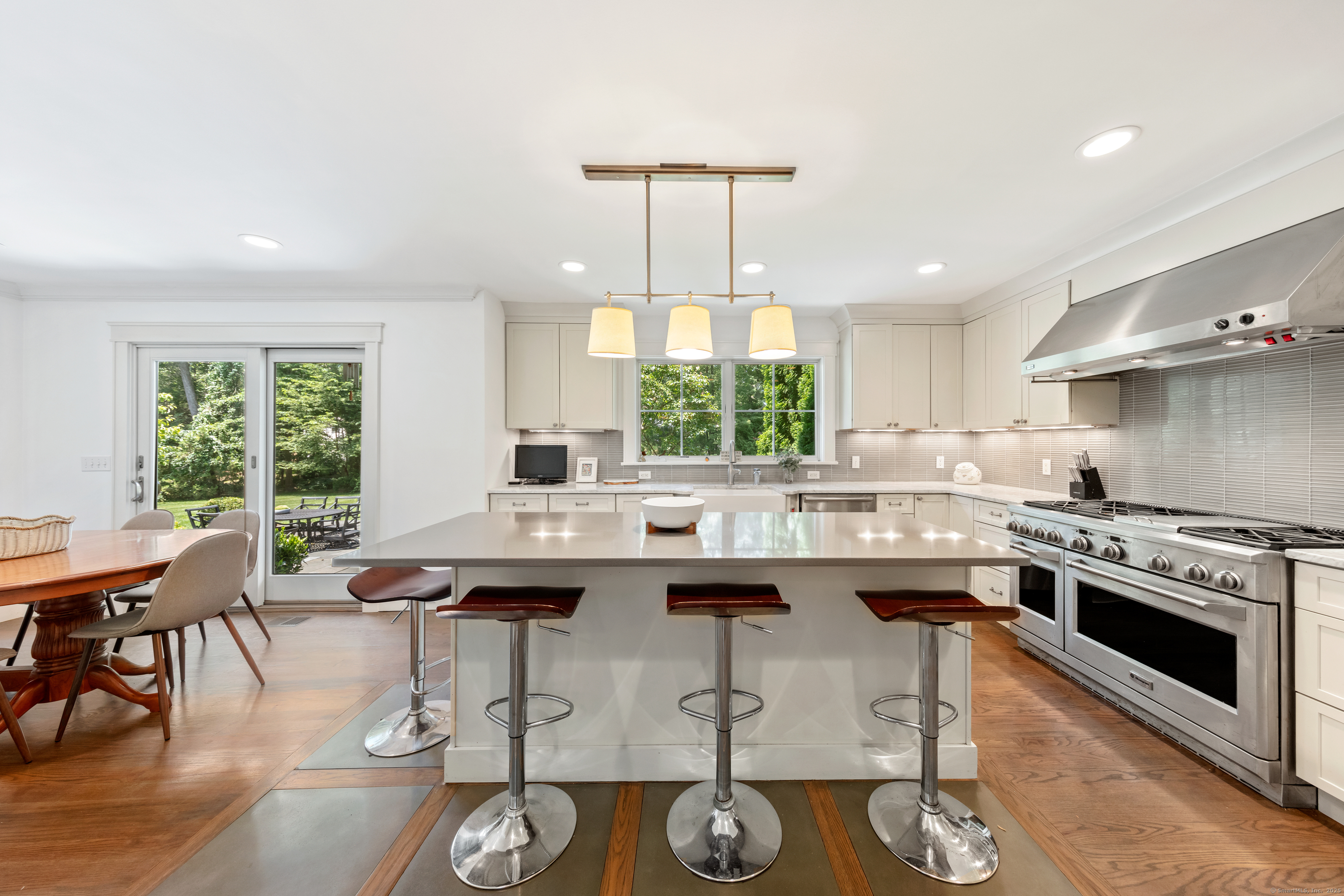 358 Hoyt Street Darien, CT 06820 - Photo 16 of 40 a kitchen with a stove a sink cabinets and dining table