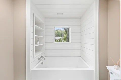 a bathroom with bathtub and window