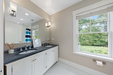 a bathroom with a double vanity sink and large window