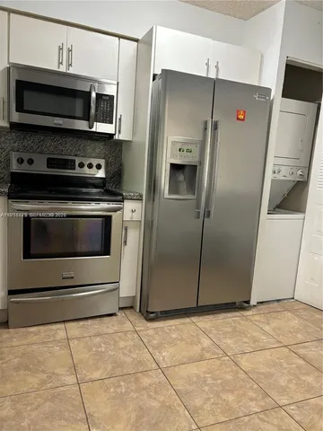 a metallic refrigerator freezer sitting in a kitchen