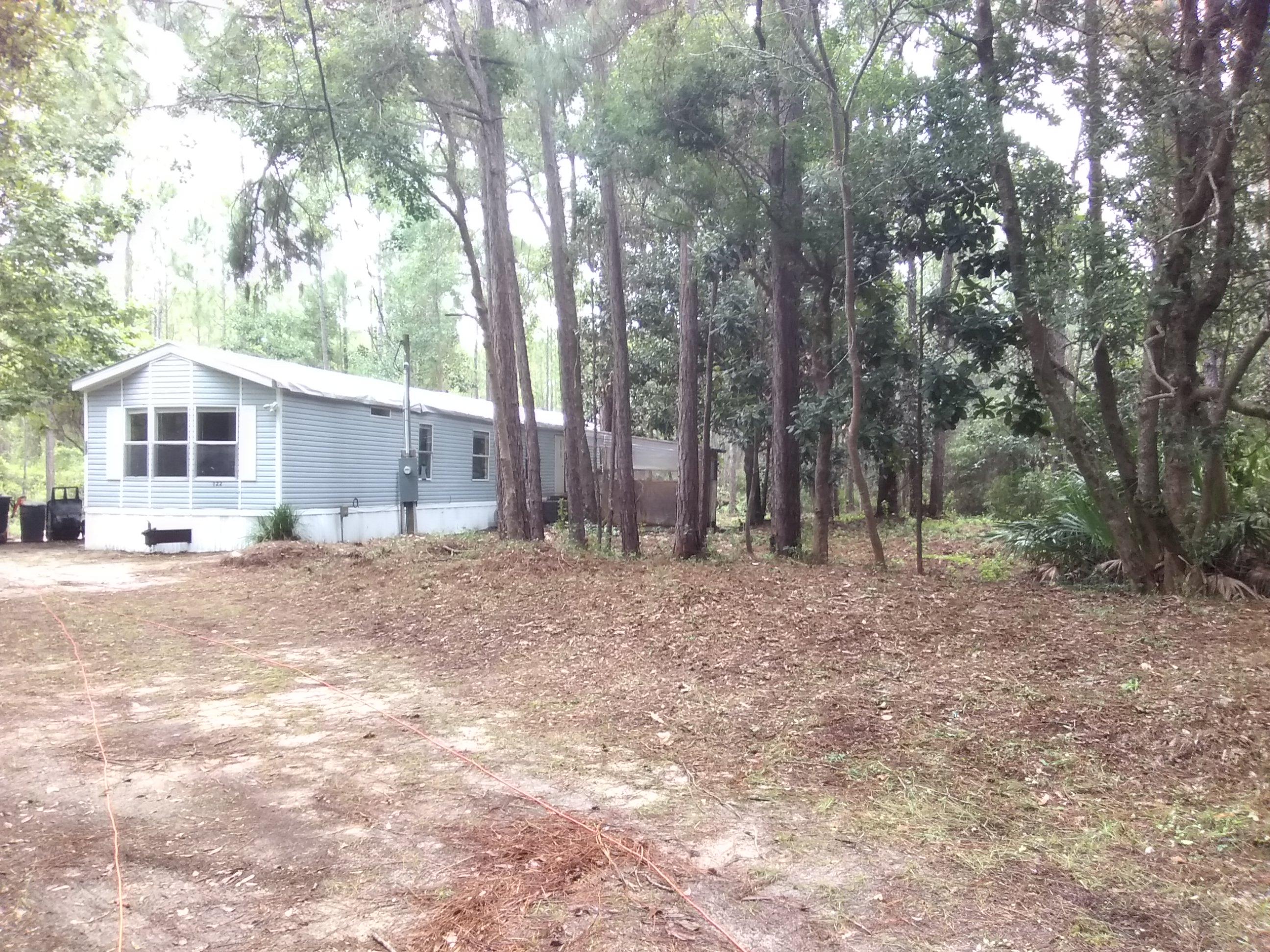 122 Santa Rosa Street Santa Rosa Beach, FL 32459 - Photo 1 of 3 a front view of a house with a yard and large trees