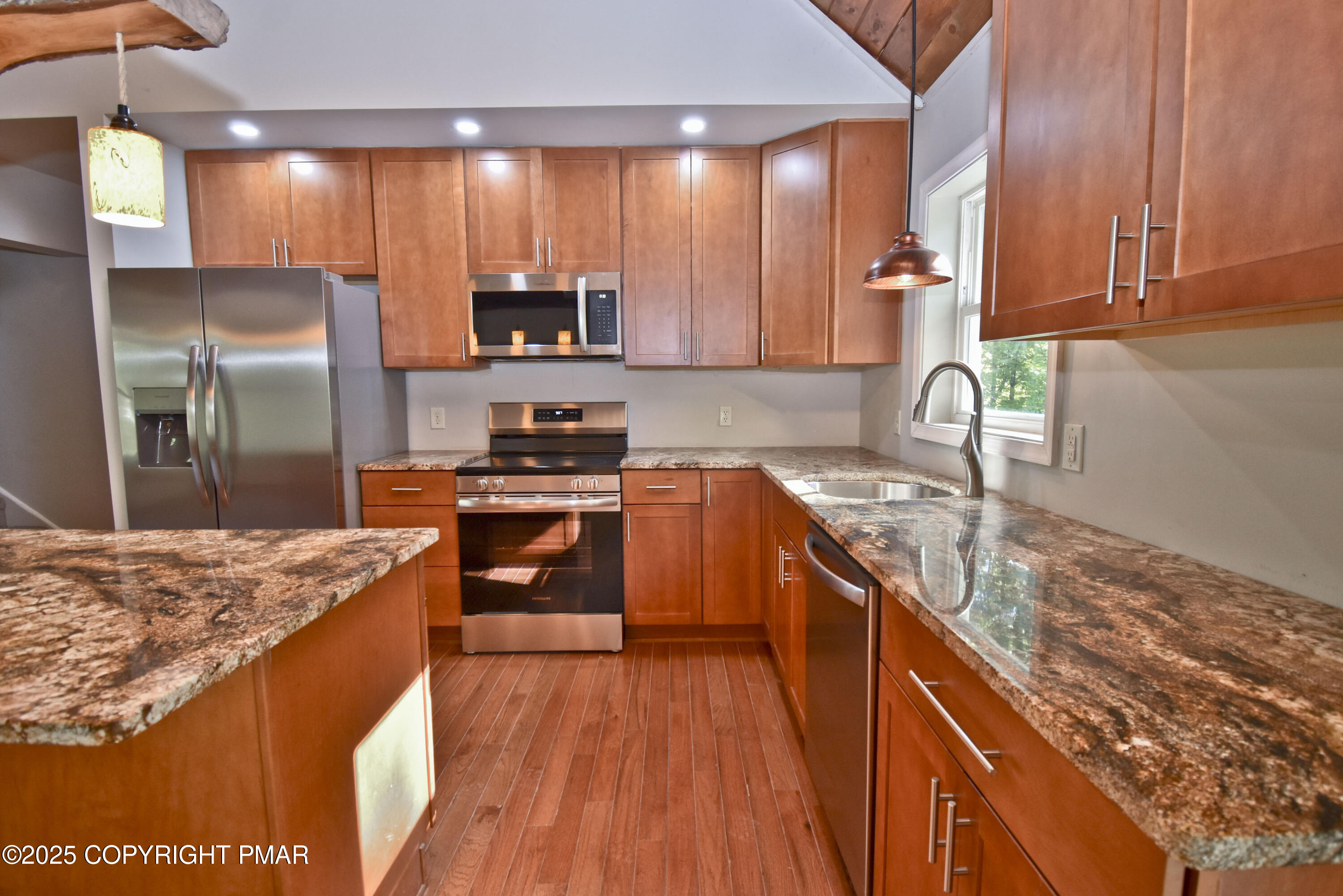 348 Summit Road Swiftwater, PA 18370 - Photo 10 of 47 a kitchen with stainless steel appliances granite countertop a sink a stove top oven a refrigerator with wooden floors and granite countertops
