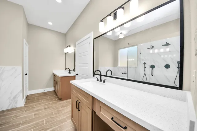 a bathroom with a sink mirror and a shower