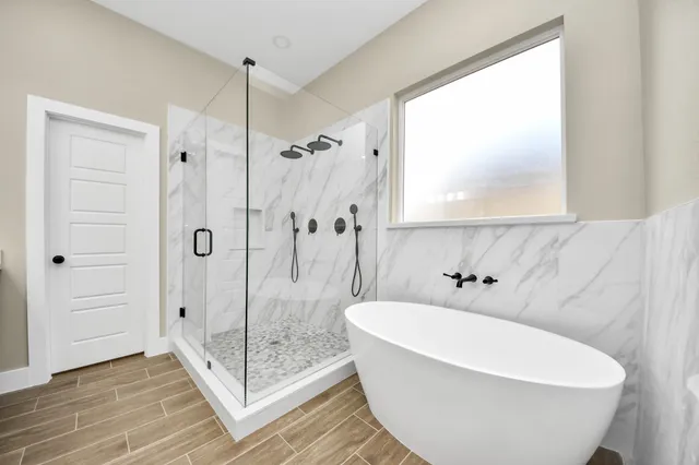 a white bath tub sitting next to a shower