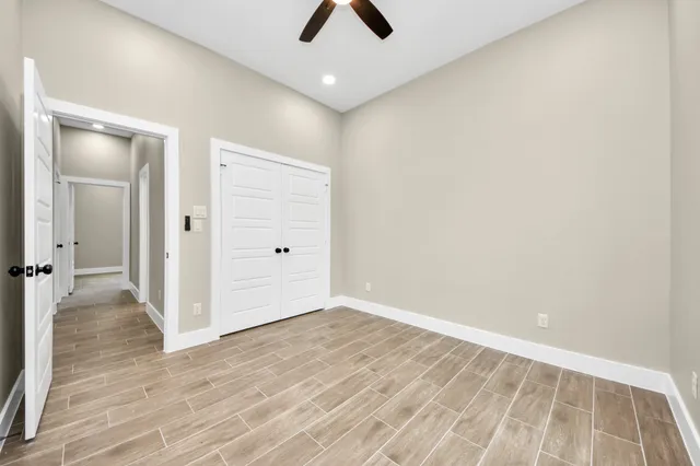 wooden floor in an empty room with a ceiling fan