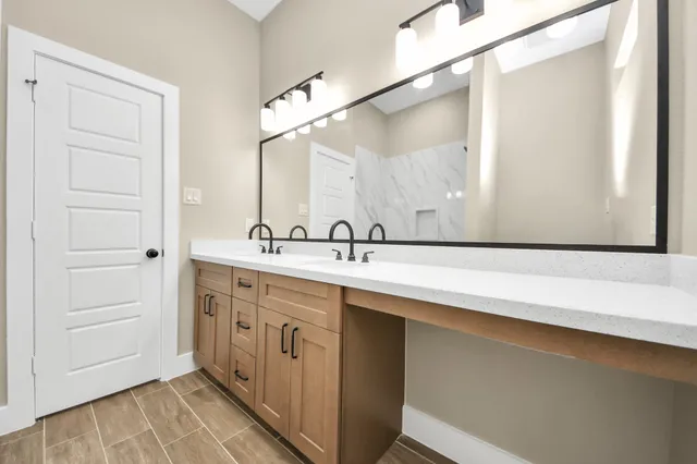 a bathroom with a double vanity sink and mirror